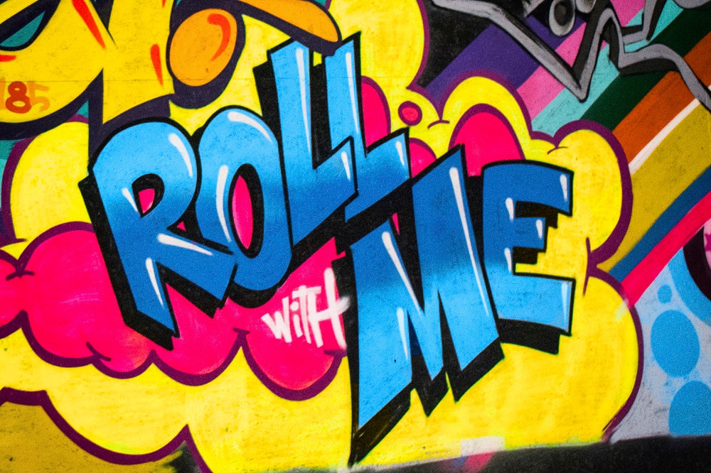 Graffiti bij Roller Planet met de tekst Roll with me in Amsterdam.